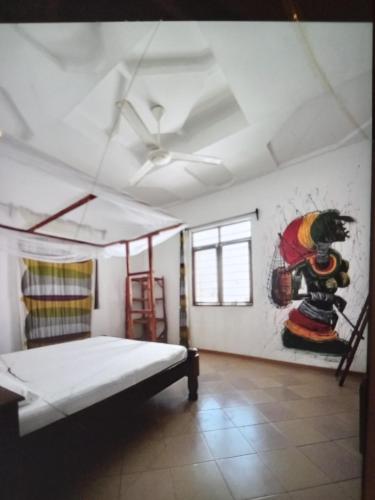 1 dormitorio con 1 cama y una pintura en la pared en Wakanda Nungwi, en Nungwi