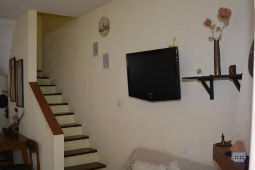 a television hanging on a wall in a living room at Παραθαλάσσια μεζονέτα! in Kamena Vourla