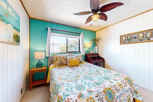 a bedroom with a bed and a ceiling fan at Pelican Harbor in Rockaway Beach