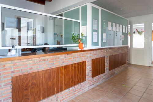 a restaurant with a bar with wood and glass at Hotel Oasis Atalaya in Conil de la Frontera