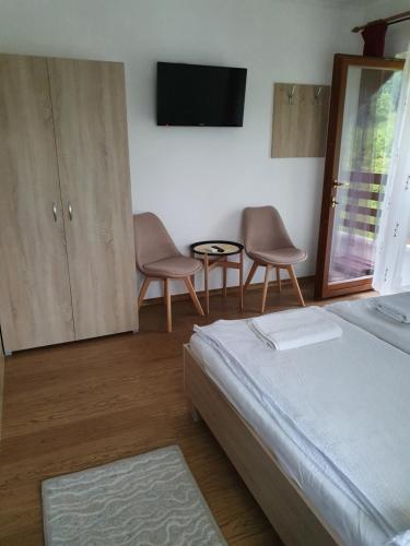 1 dormitorio con 1 cama, 2 sillas y TV en Casa Toth, en Sovata