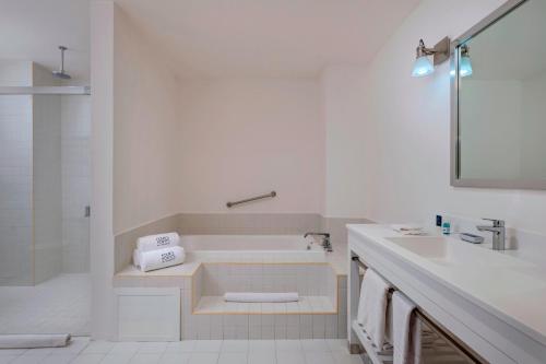 Baño blanco con bañera y lavamanos en Four Points by Sheraton Cancun Centro, en Cancún