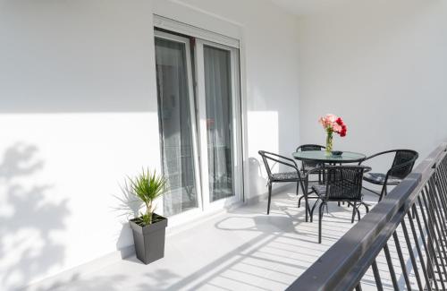 a patio with a table and chairs on a balcony at Djukic Apartmani in Tivat
