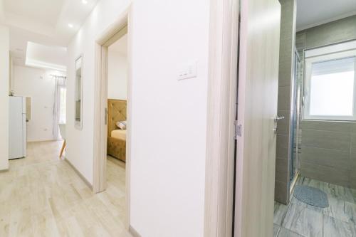 een badkamer met een inloopdouche naast een slaapkamer bij Djukic apartmani in Tivat