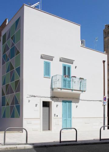 a white building with a balcony on the side of it at Vico Torto Maison in Barletta