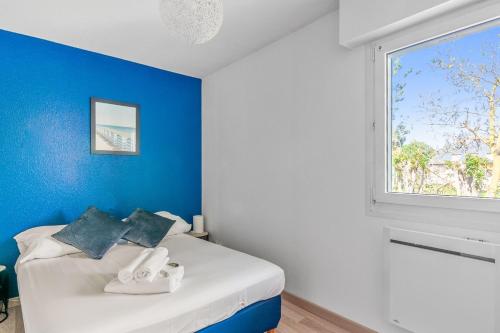 Schlafzimmer mit blauen Wänden und einem Bett mit Fenster in der Unterkunft Charming 1br with sunny balcony - Houlgate - Welkeys in Houlgate