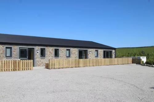 un edificio con una valla delante en The Moo-tel at Bargoed Farm en Aberaeron