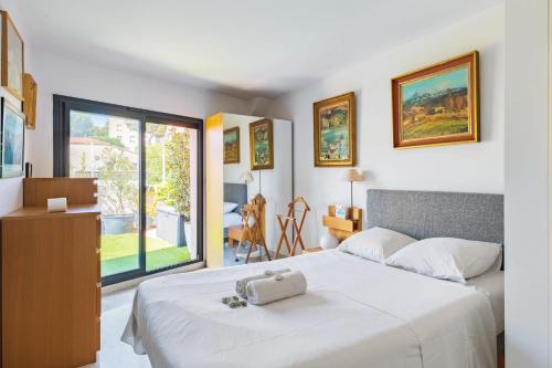 une chambre avec un lit blanc et une grande fenêtre dans l'établissement Appartement Gaston - Welkeys, à Marseille