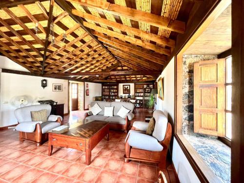 a living room with couches and a table at Apto en una casa rural, con cocina, piscina, barbacoa compartidas y vistas en Sur de Tenerife in San Miguel de Abona
