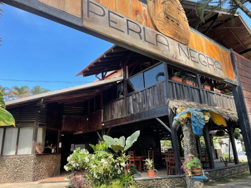 a restaurant with a sign on the side of a building at Perla Negra Beachfront in Puerto Viejo