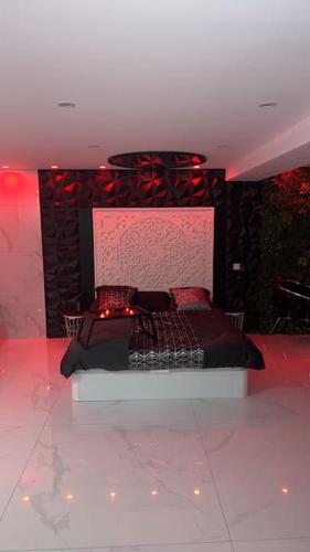 Un dormitorio con una cama con luces rojas. en Love room borabora, en Reyrieux