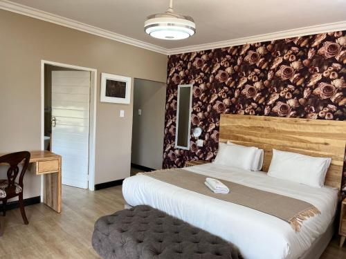 a hotel room with a large bed and a desk at Thabazimbi Country Lodge in Thabazimbi