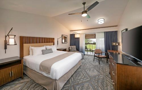 a hotel room with a bed and a flat screen tv at Half Moon Bay Lodge in Half Moon Bay