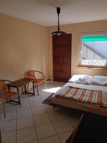 a bedroom with a bed and a table and a window at Pokoje goscinne in Kołobrzeg