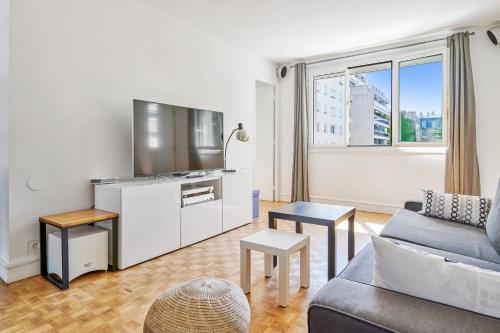 un salon avec un canapé et une télévision dans l'établissement Appartement Garibaldi - Welkeys, à Paris