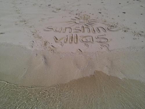 a sign written in the sand on the beach at Korovesi Sunshine Villas in Savusavu
