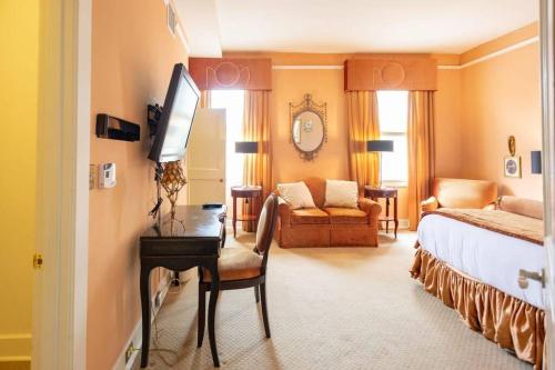 ein Hotelzimmer mit einem Bett und einem Schreibtisch mit einem TV in der Unterkunft Nice + Cozy Studio in Durham, steps away from Duke in Durham