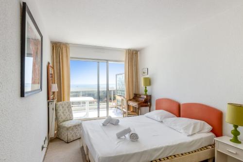 une chambre d'hôtel avec un lit et un balcon dans l'établissement Appartement Orangerie - Welkeys, à Antibes