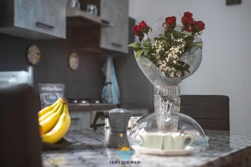 a vase with flowers on a table in a kitchen at Tra i due mari in Ruffano