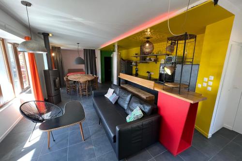 salon z czarną kanapą i żółtą ścianą w obiekcie Le Postillon Quinto w mieście Entremont-le-Vieux