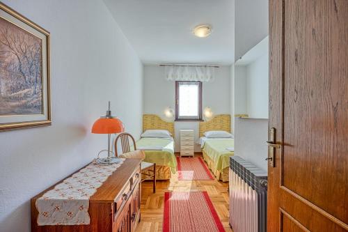 a bedroom with two beds and a table in it at Apartment Valnea in Poreč