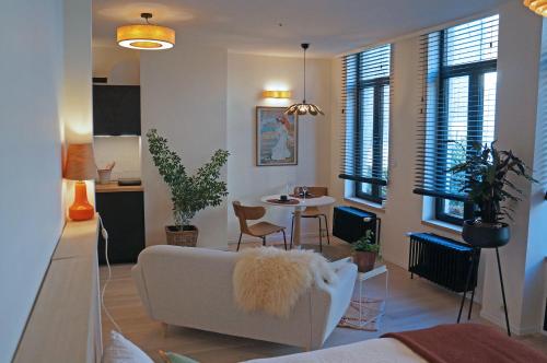 een woonkamer met een witte bank en een tafel bij l'ostendaise in Oostende