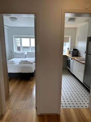 a bedroom with a bed and a kitchen with a mirror at Reykjavík Central Apartments in Reykjavík