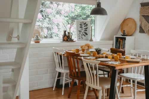 una sala da pranzo con tavolo e sedie di Boshuisje Rekem - Boris a Lanaken
