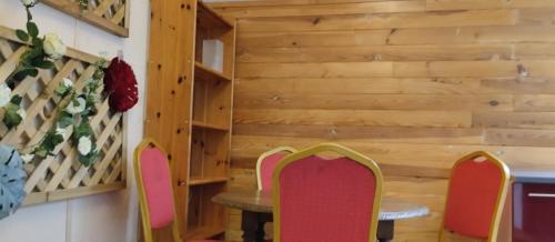 een tafel en stoelen in een kamer met houten wanden bij La Maison du Saule in Pompignac