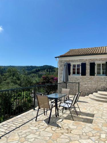 a patio with chairs and a table and an umbrella at Villa Christina in Lákka