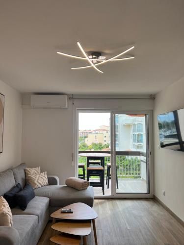 ein Wohnzimmer mit einem Sofa und einem Deckenventilator in der Unterkunft Belle vue in Cap d'Agde