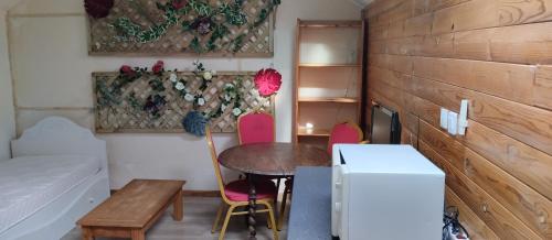 een kleine kamer met een tafel en stoelen en een bed bij La Maison du Saule in Pompignac