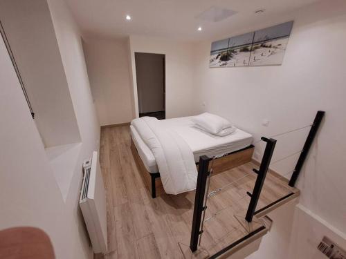 une petite chambre avec un lit et un miroir dans l'établissement Maisonnette à 1 km de la plage, à Berck-sur-Mer