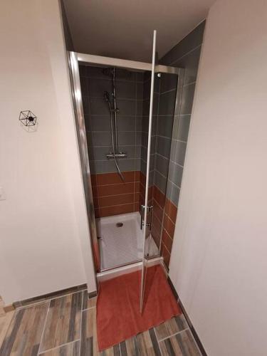 une salle de bain avec une douche avec une porte vitrée dans l'établissement Maisonnette à 1 km de la plage, à Berck-sur-Mer