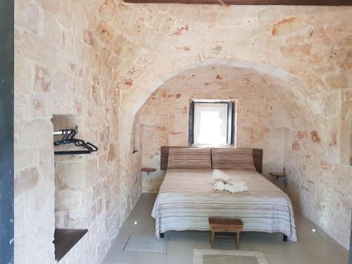 una camera con un letto in una parete in pietra di Trullo Victory a Martina Franca