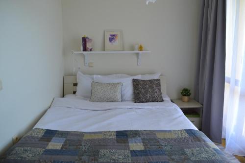 ein Bett mit zwei Kissen darauf in einem Schlafzimmer in der Unterkunft Апартамент в Oasis beach Kamchia - Стъпки в пясъка in Kamchia