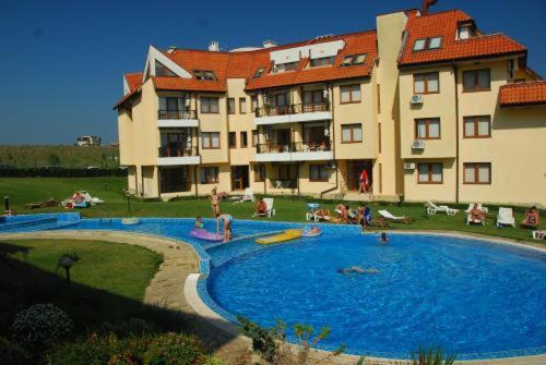 a large swimming pool in front of a large building at Апартамент в Oasis beach Kamchia - Стъпки в пясъка in Kamchia