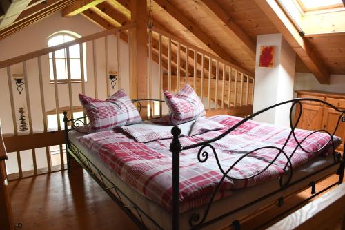 1 dormitorio con 1 cama con almohadas rosas y blancas en Ferienwohnung Glück, en Saaldorf-Surheim