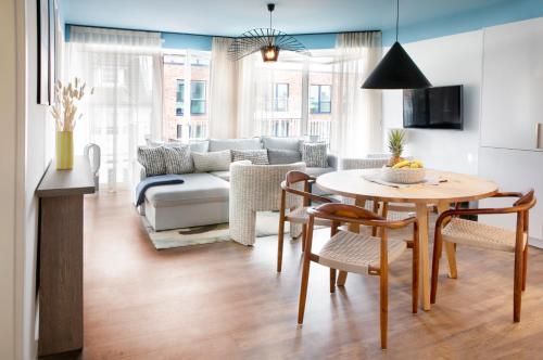 Seehuus Duhnen Apartments في كوكسهافن: غرفة معيشة مع طاولة وأريكة
