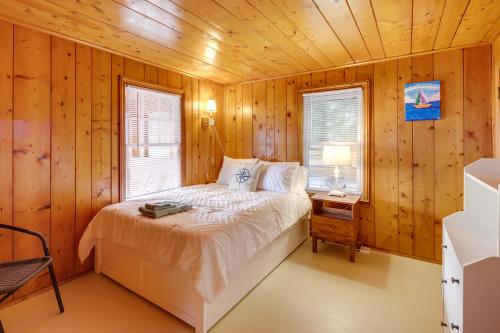 una camera da letto con un letto in una stanza di legno di Waterfront Cottage with Sunroom and Patio and Grill a Clinton