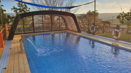 Piscine de l'établissement מרגנית בגליל - בקתות כפריות מקסימות עם ג'קוזי פרטי מול נוף משגע ובריכה גדולה במתחם - Wooden cabins with a private jacuzzi in front of a Galilean view and a big swimming pool in the complex ou située à proximité
