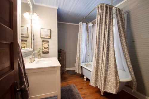 ein Badezimmer mit einem Waschbecken, einer Badewanne und einer Dusche in der Unterkunft Belton Bed and Breakfast in Belton