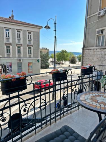 a balcony with a table with potted plants on it at Villa Olivetta heritage residence in Crikvenica