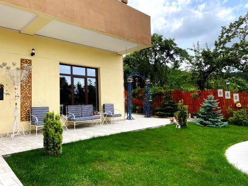 a house with two chairs and a yard at Hotel Legiandro Surami in Surami