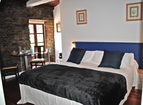 a bedroom with a large bed with a blue wall at LA GALLEGA in Valdoviño