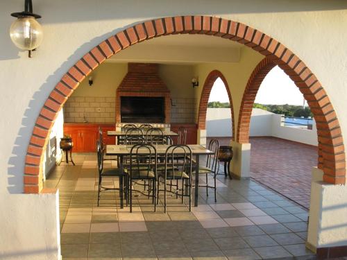 eine Terrasse mit einem Torbogen mit Tischen und Stühlen in der Unterkunft EDIFICIO ASUNCIÓN in Asunción