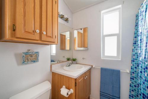 a bathroom with a sink and a toilet and a window at Snug Harbor RV Park & Marina in Walnut Grove