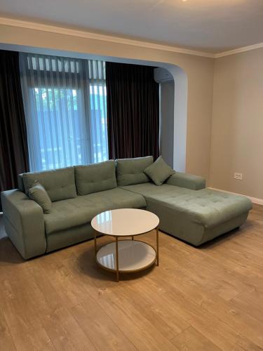 uma sala de estar com um sofá verde e uma mesa em Apart Central em Orşova