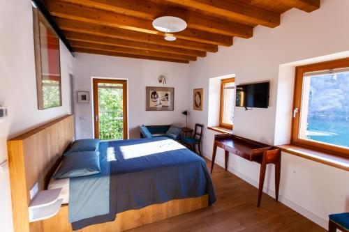 a bedroom with a bed and a desk and a television at B&B Villa Grazia in Darfo