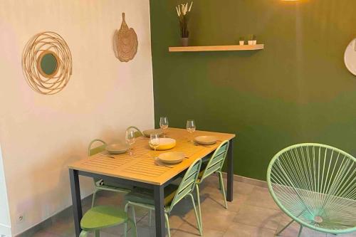 a wooden table with chairs and wine glasses on it at Maison de pêcheur-Étaples (proche Touquet) in Étaples